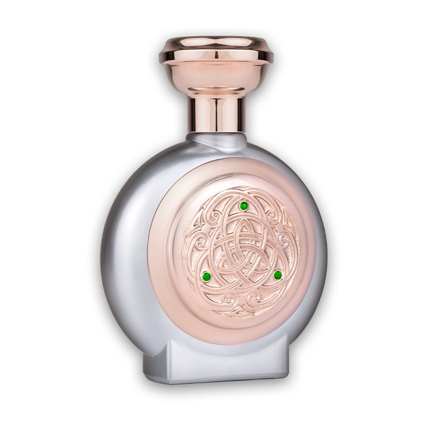 Side view of the Decadence perfume bottle in silver with a rose gold shield and three green diamonds, highlighting its elegant profile and ornate detailing.